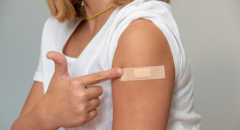 Plåster på en arm efter en vaccinspruta. Foto.
