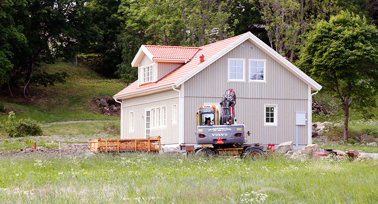 En nybyggd villa och en grävmaskin. Foto: Roland Magnusson/Mostphotos