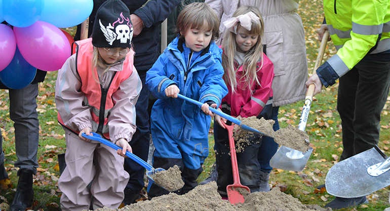 Förskolebarn gräver de första spadtagen till en ny förskola. Foto.