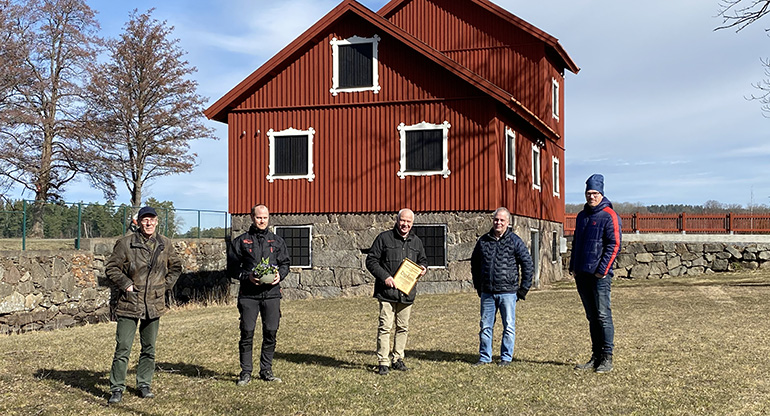 Pristagare och prisutdelare framför kvarnen i Klavreström. Foto.